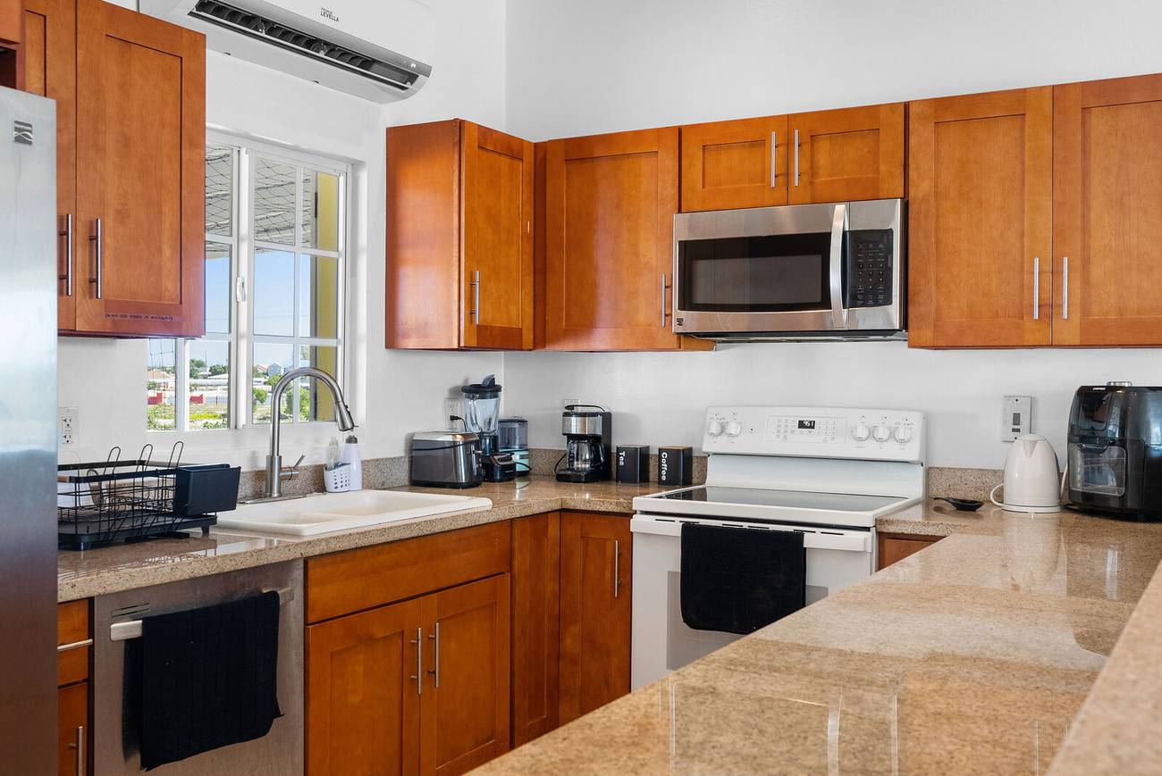 Fully equipped kitchen with wooden cabinets and granite counters