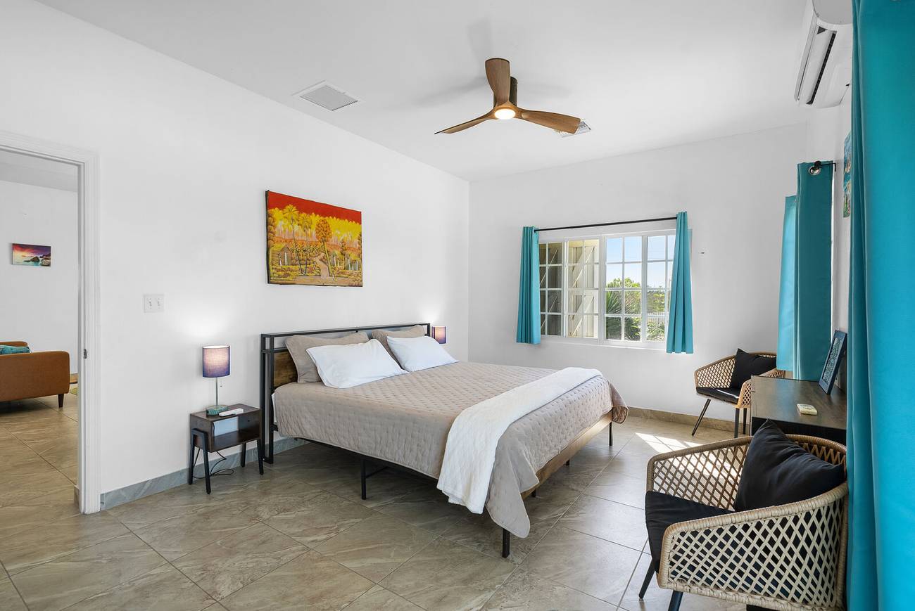 Bedroom with queen bed and turquoise curtains